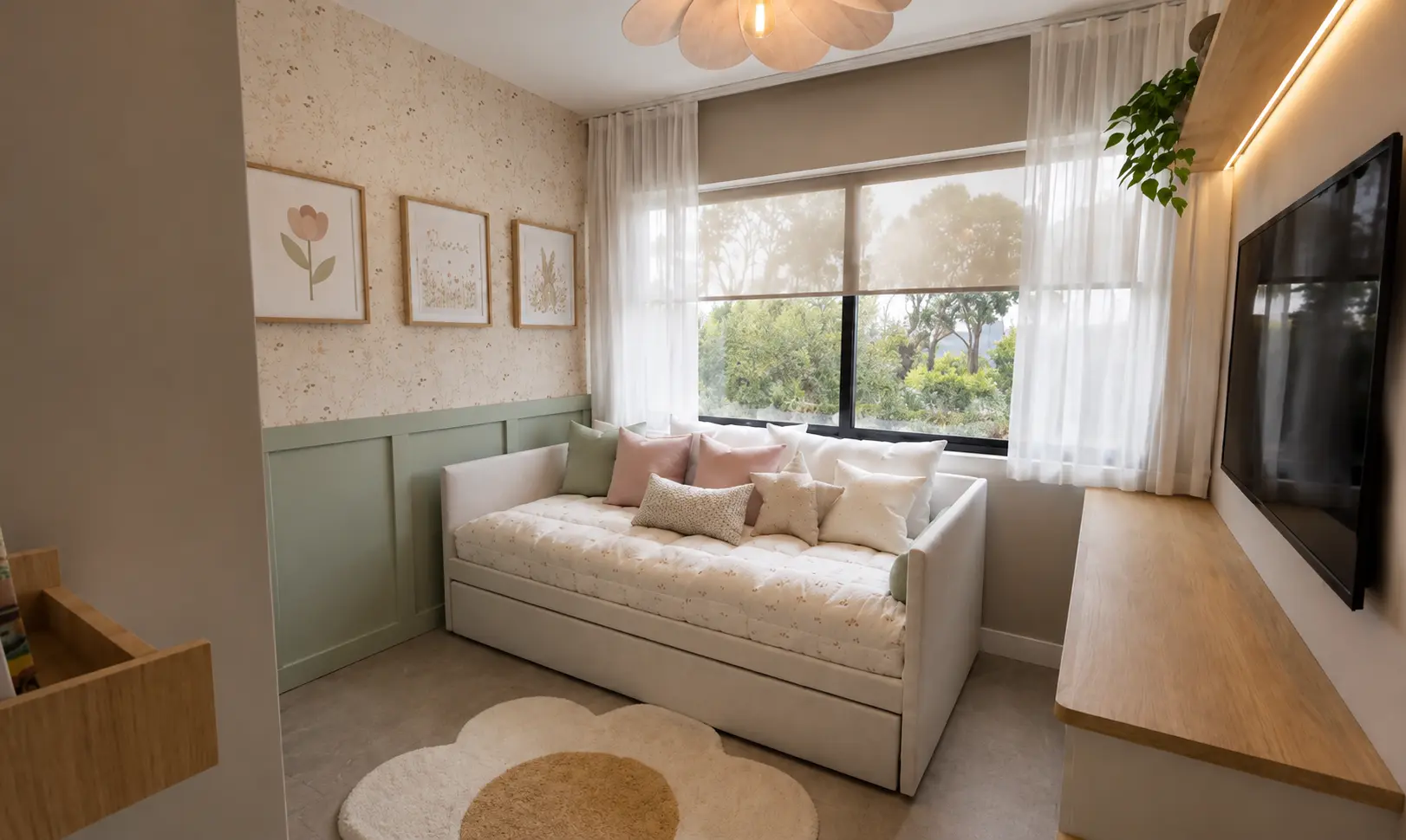 Cuarto de Niña — Residencial · Dormitorio infantil Dormitorio infantil femenino con papel tapiz floral delicado, boiserie verde salvia, sofá cama blanco con cojines rosa y crema, cuadros enmarcados, cortinas de velo y tapete en forma de flor