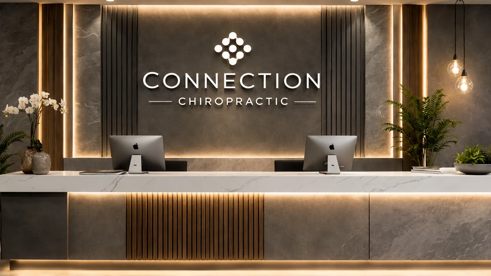 Primera impresión: tu recepción Recepción comercial de clínica quiropráctica con muro de piedra gris iluminado, logotipo retroiluminado, listones de madera, mostrador de mármol blanco y plantas decorativas